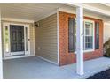Welcoming front porch with a black door, brick accents, and white pillars for a stylish entrance at 1910 Charleston Oak Cir, Lawrenceville, GA 30043