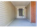 Inviting front entry featuring a black door, beige siding, and a covered porch at 1910 Charleston Oak Cir, Lawrenceville, GA 30043