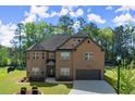 Attractive brick house with well-maintained landscaping and a paved driveway leading to an attached garage at 404 Prague Way, Hampton, GA 30228