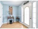 Bright entryway with hardwood floors and a decorative front door and a sign with 