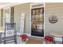 Charming front door with sidelights, decorative wreath, and cozy rocking chair at 498 Trip St, Grayson, GA 30017