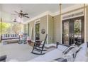 Inviting covered porch with rocking chairs, swing seating, and ceiling fans for relaxing outdoors at 498 Trip St, Grayson, GA 30017