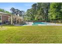 Expansive backyard featuring a covered patio and inviting in-ground pool at 3127 Hidden Forest Dr, Snellville, GA 30078