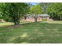 Well-maintained brick home with a sprawling green lawn and mature trees at 3127 Hidden Forest Dr, Snellville, GA 30078