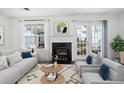 Bright living room features fireplace, neutral furniture, large windows, and access to outdoor patio at 6703 Gallant Se Ct, Mableton, GA 30126