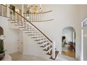 Grand foyer featuring a curved staircase, decorative chandelier, and elegant tile flooring at 2000 Old Dominion Rd, Atlanta, GA 30350