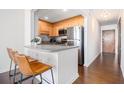Galley kitchen featuring stainless steel appliances, breakfast bar with seating, and hardwood flooring at 215 Piedmont Ne Ave # 1110, Atlanta, GA 30308