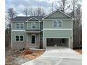 Inviting two-story home with green siding, a two-car garage, and a covered front porch at 66 Pine Creek Ct, Dallas, GA 30157