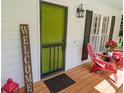 Charming front porch features a green front door, shutters, and rocking chairs at 5245 Cherry Hill Ln, Powder Springs, GA 30127