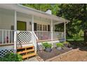 Inviting covered front porch with a lovely lattice surround and wood decking at 5245 Cherry Hill Ln, Powder Springs, GA 30127