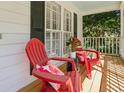 Relaxing front porch seating area with red Adirondack chairs and lattice railing at 5245 Cherry Hill Ln, Powder Springs, GA 30127