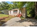 Charming tan home with a concrete drive, complemented by mature trees at 2383 Baker Nw Rd, Atlanta, GA 30318
