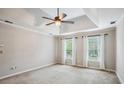 Spacious bedroom with tray ceiling, carpet, ceiling fan and natural light from two windows with curtains at 4284 Windy Gap Nw Ct, Kennesaw, GA 30144