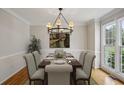 Formal dining room with a chandelier, a table set for six, and a large window offering natural light at 4284 Windy Gap Nw Ct, Kennesaw, GA 30144