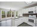 Well-lit kitchen with white cabinets, modern appliances, and an adjacent dining area with sliding glass doors to the deck at 4284 Windy Gap Nw Ct, Kennesaw, GA 30144
