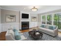 Inviting living room featuring a fireplace, large windows with outdoor views, and neutral-toned furniture at 4284 Windy Gap Nw Ct, Kennesaw, GA 30144