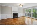 Bright living room featuring hardwood floors, a fireplace, and large windows overlooking a wooded area at 4284 Windy Gap Nw Ct, Kennesaw, GA 30144
