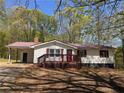 A cozy single-story home with white siding, complemented by red shutters and a charming front porch at 5130 English Dr, Cumming, GA 30041