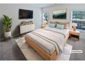 Staged main bedroom featuring a bed with nightstands, dresser with television, and windows with blinds at 5763 Mitchell Chase Trl, Mableton, GA 30126