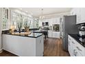 A modern kitchen with white cabinetry, dark countertops, stainless steel appliances, and a large bay window at 2125 Fairfax Dr, Alpharetta, GA 30009