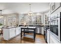 Bright kitchen featuring stainless appliances, light cabinetry, granite countertops, and large windows overlooking the yard at 2125 Fairfax Dr, Alpharetta, GA 30009