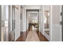 Elegant hallway with hardwood floors, decorative rug, and glass-paneled doors leading to bright living spaces at 347 Woodridge Pass, Canton, GA 30114