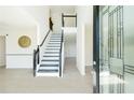 Bright foyer featuring sleek floors, a modern staircase, and an elegant glass front door at 3554 Cherry Bloom Way, Decatur, GA 30034