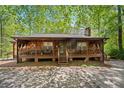 Charming log cabin with a covered front porch and a serene wooded setting at 4288 Post Rd, Winston, GA 30187