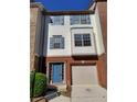 Attractive two-story townhome with blue door, attached garage, and brick accents at 528 Lantern Wood Dr, Scottdale, GA 30079