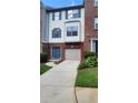A charming townhome with brick and vinyl siding, a one-car garage, and a well-manicured lawn at 528 Lantern Wood Dr, Scottdale, GA 30079