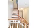 Bright staircase with white risers, hardwood treads, and stylish wooden railing at 528 Lantern Wood Dr, Scottdale, GA 30079