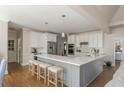 Spacious kitchen featuring a large island, white cabinetry, stainless steel appliances, and hardwood floors at 10575 Wren Ridge Rd, Alpharetta, GA 30022