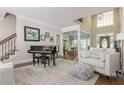 Bright, neutral living room with high ceilings, hardwood floors, piano, and a rug that brings the room together at 10575 Wren Ridge Rd, Alpharetta, GA 30022