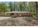 Well-maintained single-story brick home with a carport and mature trees at 1093 Lanier Sw Dr, Marietta, GA 30060