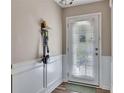 Bright entryway with white wainscoting, a door with blinds, and convenient wall hooks for accessories at 373 Hidden Creek Ln, Canton, GA 30114