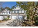 Inviting two-story home with a two-car garage and well-kept yard on a sunny day, great curb appeal at 373 Hidden Creek Ln, Canton, GA 30114
