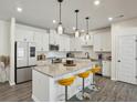 Bright, modern kitchen featuring white cabinetry, a granite island with seating, and stainless steel appliances at 375 Crider Ct, Woodstock, GA 30188