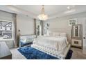 Luxurious main bedroom boasts a tray ceiling, a plush bed, mirrored furniture, and large windows at 375 Crider Ct, Woodstock, GA 30188