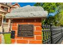 Historical brick pillar with cast iron fencing showing a plaque designating The Palmour House to the historic registry at 3593 Hemphill St, Atlanta, GA 30337