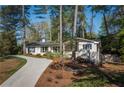 Aesthetic white brick home featuring a winding drive, mature landscaping, and multiple windows at 2590 Hawthorne Ne Pl, Atlanta, GA 30345
