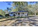 Scenic view of a charming single-story home with a covered porch surrounded by mature trees at 21 W Lake Dr, Oxford, GA 30054