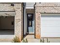 Close-up of the front door of a townhome with brick accents and an attached garage at 1016 Rose Dr, Marietta, GA 30060