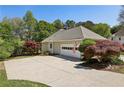 Spacious home garage with a large driveway, an American flag, and mature landscaping at 3925 Waterford Dr, Suwanee, GA 30024
