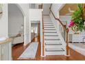 Bright foyer with hardwood floors, staircase, and views into the formal living room, creating an inviting entrance at 4013 Suwanee Place Dr, Suwanee, GA 30024