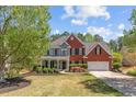 Attractive two-story home with brick and siding, a lush green lawn, and a welcoming covered porch at 4013 Suwanee Place Dr, Suwanee, GA 30024