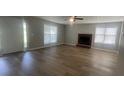 Bright living room featuring a fireplace, laminate floors, and natural light from multiple windows at 3870 Spring Moss Cir, Snellville, GA 30039