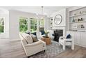 Bright living room with hardwood floors, fireplace, built-in bookshelves, and large windows at 1019 Cooks Farm Way, Woodstock, GA 30189