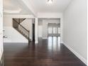 Bright entryway featuring hardwood floors, white walls, and a staircase with dark iron railing at 3002 Blue Stone Ct, Dacula, GA 30019