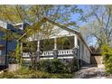 Charming home with a welcoming front porch framed by lush landscaping and driveway at 136 Flora Ne Ave, Atlanta, GA 30307