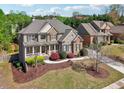 Beautifully landscaped two-story home with manicured lawn, stone facade, and an inviting front porch at 1754 Water Springs Way, Dacula, GA 30019